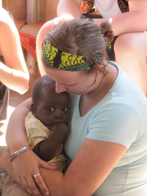 Millie Gibson holding a child from Tanzania