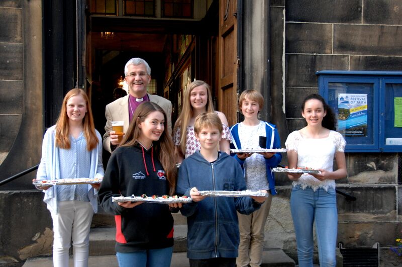 Bishop Jonathan pictured outside Holy Trinity Holmfirth with children serving canapés