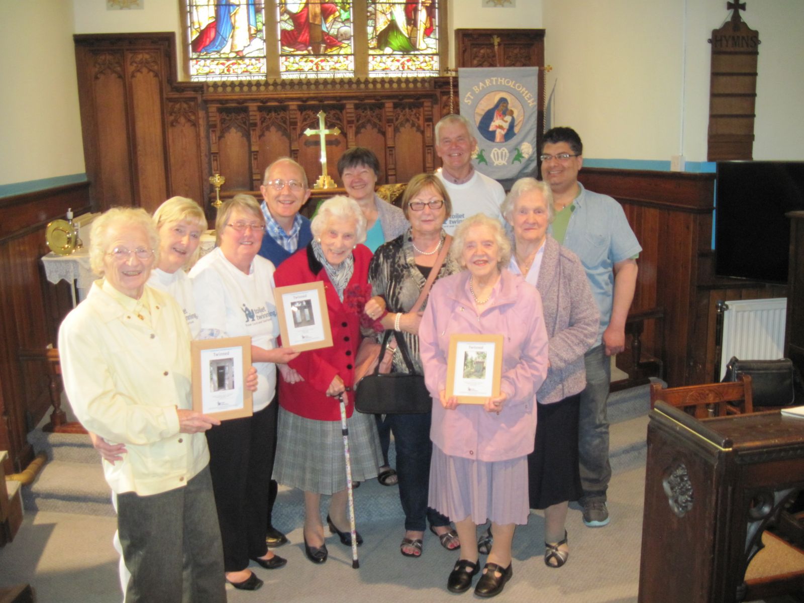 Members of Grange Moor holding the church's certificates for the Toilet Twinning