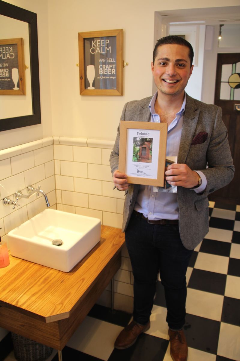 The Beaumont Arms' landlord holding the pub's certificate for the 'Toilet Twinning'