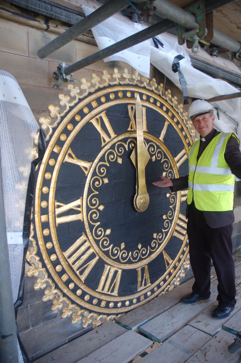 Revd Hugh Baker with the re-gilded church clock