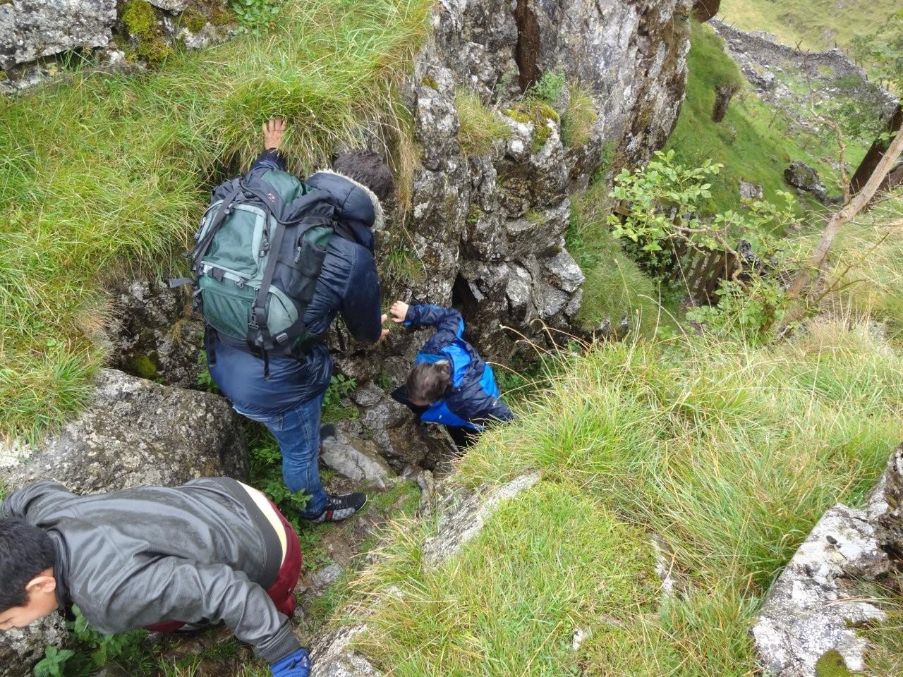 A group helping each you climb up a hill