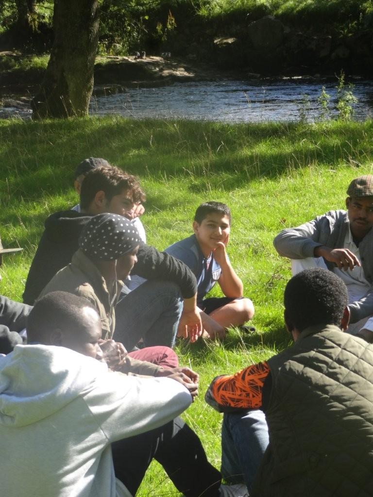 The group sat together in the sun on a river bank