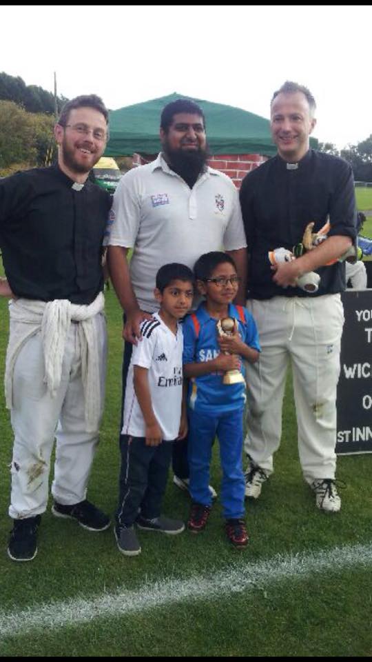 Three of the cricket players with two children at the game