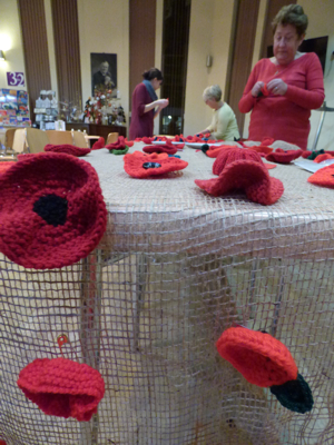 People helping attach poppies to cloth at Wakefield Cathedral