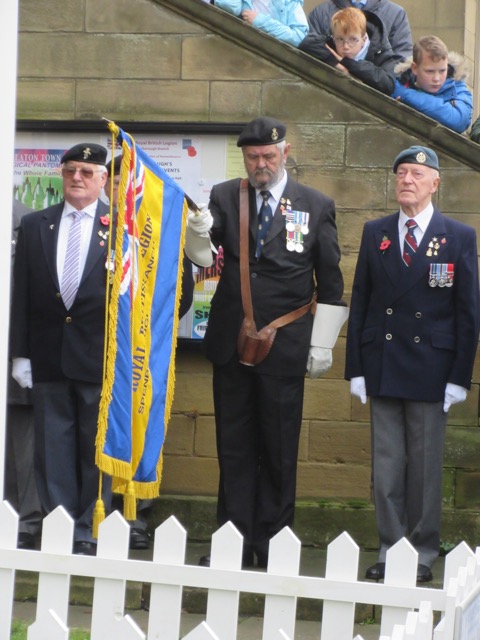 Mid-Remembrance service rising a banner and in silence