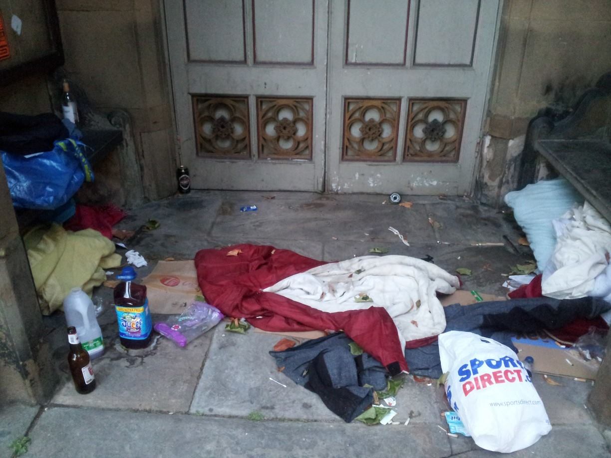 The belongings of homeless people who have slept in a church porch