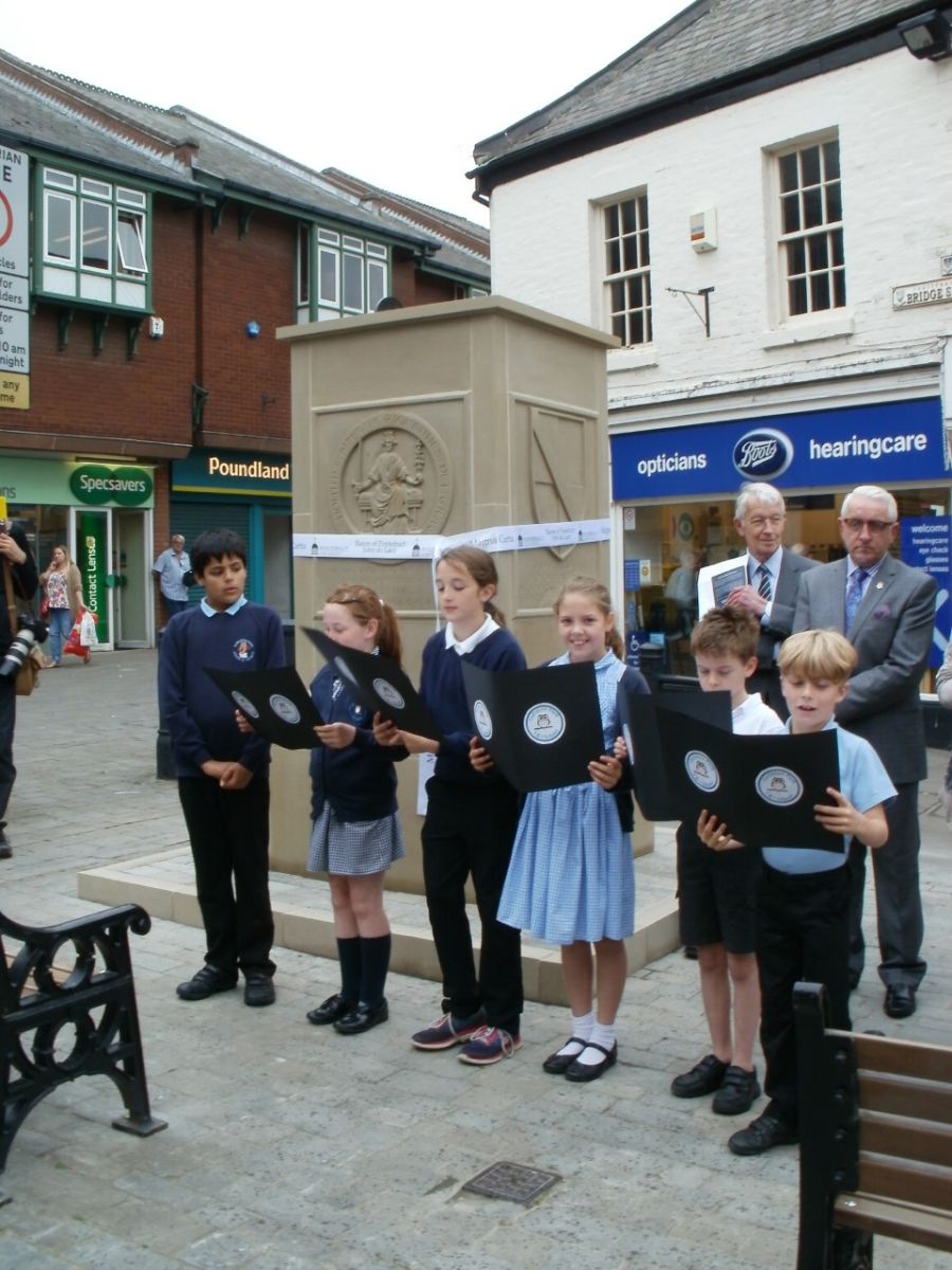 Children from Carleton Park Junior and Infants School speaking in front of the memorial